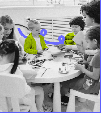 Imagem em preto e branco de crianças numa mesa desenhando e pintando